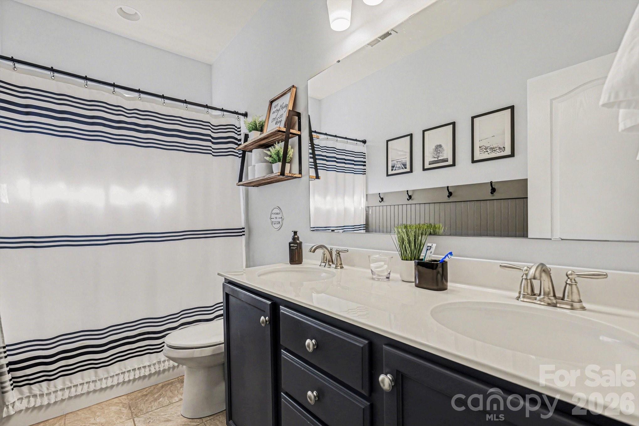 5153 Waterloo Drive Tega Cay, SC 29708 - Photo 22 of 29 a bathroom with a granite countertop sink a toilet and a mirror