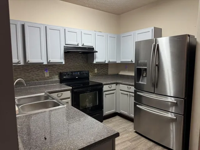 a kitchen with granite countertop stainless steel appliances and wooden cabinets