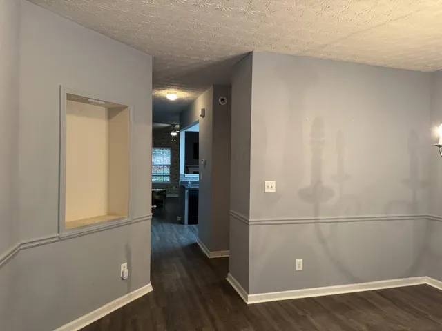 an empty room with wooden floor and entrance