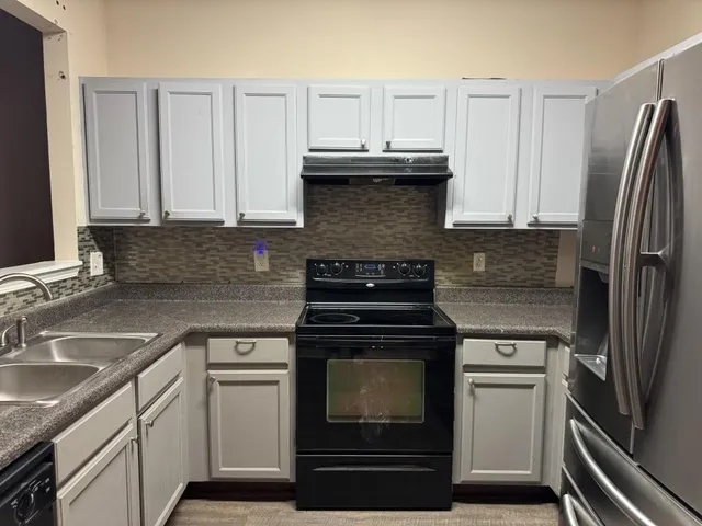 a kitchen with cabinets appliances and a sink
