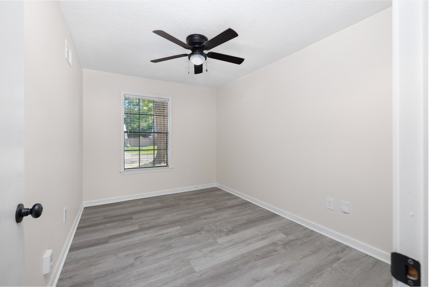 368 Tara Ridge Cove Collierville, TN 38017 - Photo 14 of 25 an empty room with wooden floor fan and windows