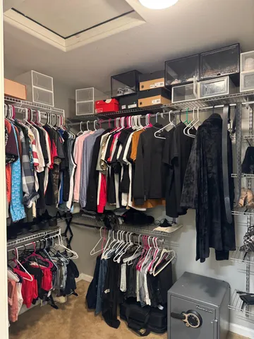 a view of walk in closet with clothes and shoes