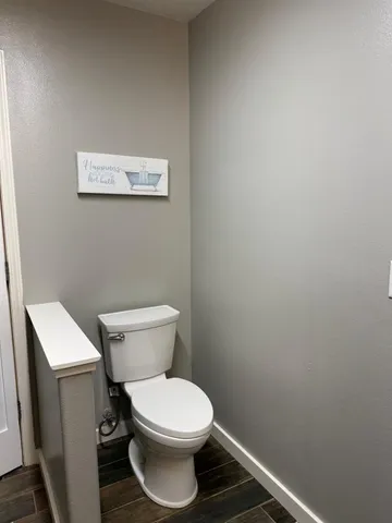 a white toilet sitting next to a white wall