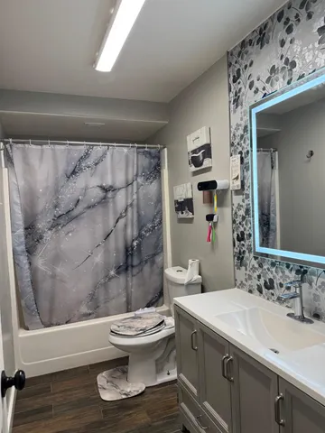 a bathroom with a granite countertop sink toilet and shower