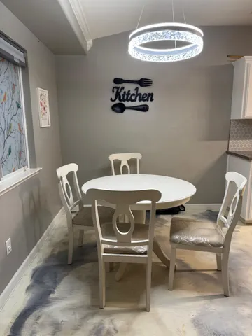 a dining room with furniture and a window