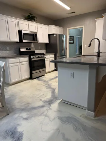 a kitchen with stainless steel appliances a stove microwave and sink