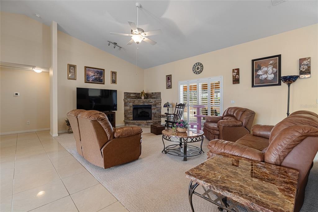 4190 Southwest 103rd Street Road Ocala, FL 34476 - Photo 31 of 55 a living room with furniture a large window and a fireplace