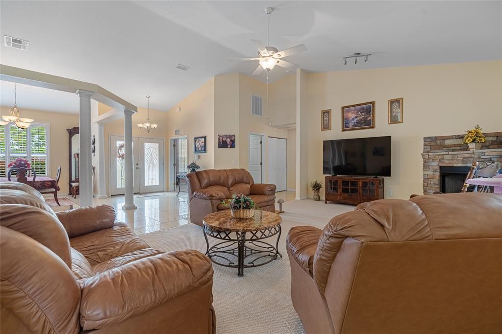 4190 Southwest 103rd Street Road Ocala, FL 34476 - Photo 32 of 55 a living room with furniture a flat screen tv and a fireplace