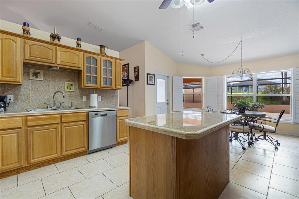 4190 Southwest 103rd Street Road Ocala, FL 34476 - Photo 36 of 55 a kitchen with stainless steel appliances granite countertop a sink and dishwasher a oven with wooden cabinets