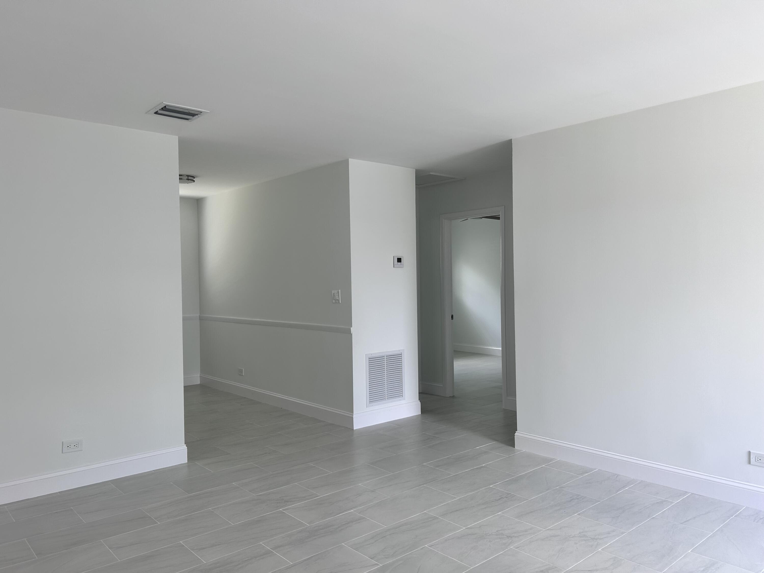 630 Prosperity Farms Road, Unit 2 North Palm Beach, FL 33408 - Photo 8 of 13 an empty room with closet and a chandelier fan