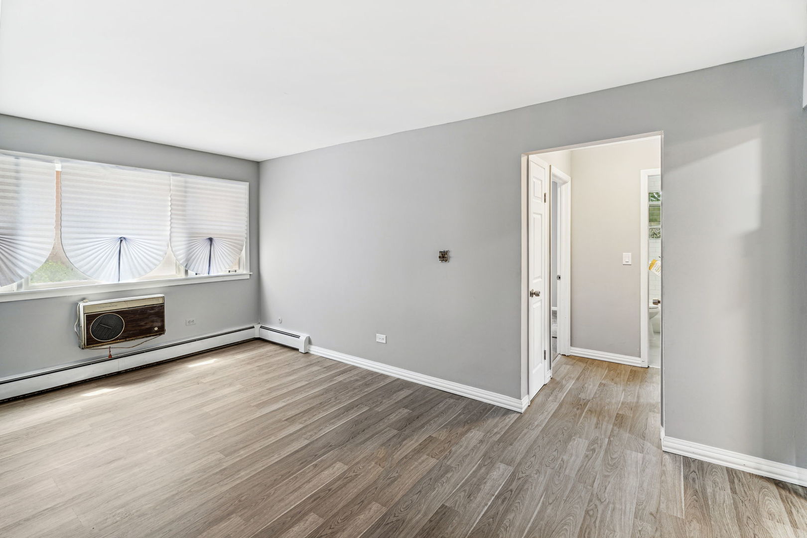 4247 North Keystone Avenue, Unit 1 Chicago, IL 60641 - Photo 14 of 18 a view of an empty room with wooden floor and a window