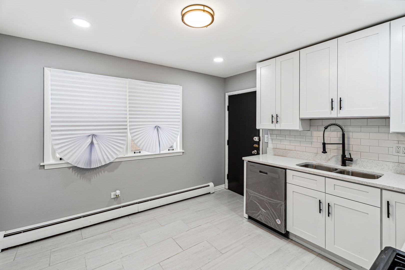 4247 North Keystone Avenue, Unit 1 Chicago, IL 60641 - Photo 9 of 18 a kitchen with stainless steel appliances granite countertop white cabinets sink and window