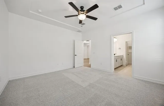 an empty room with closet and a ceiling fan
