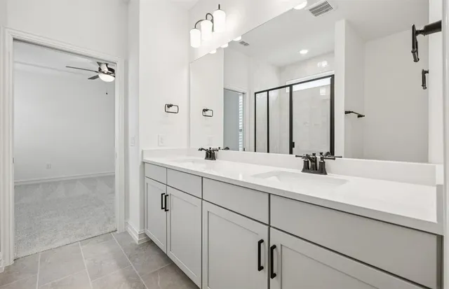 a bathroom with a double vanity sink mirror and shower