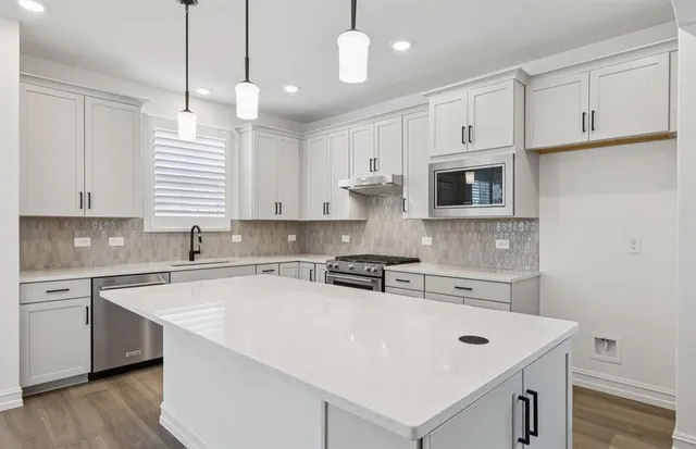 a kitchen with kitchen island white cabinets and white appliances