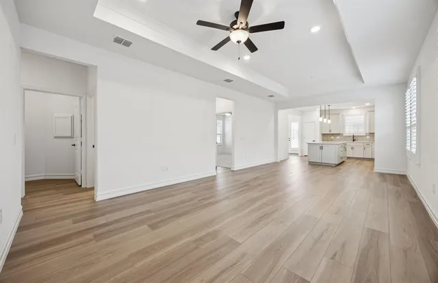 wooden floor in an empty room with a kitchen