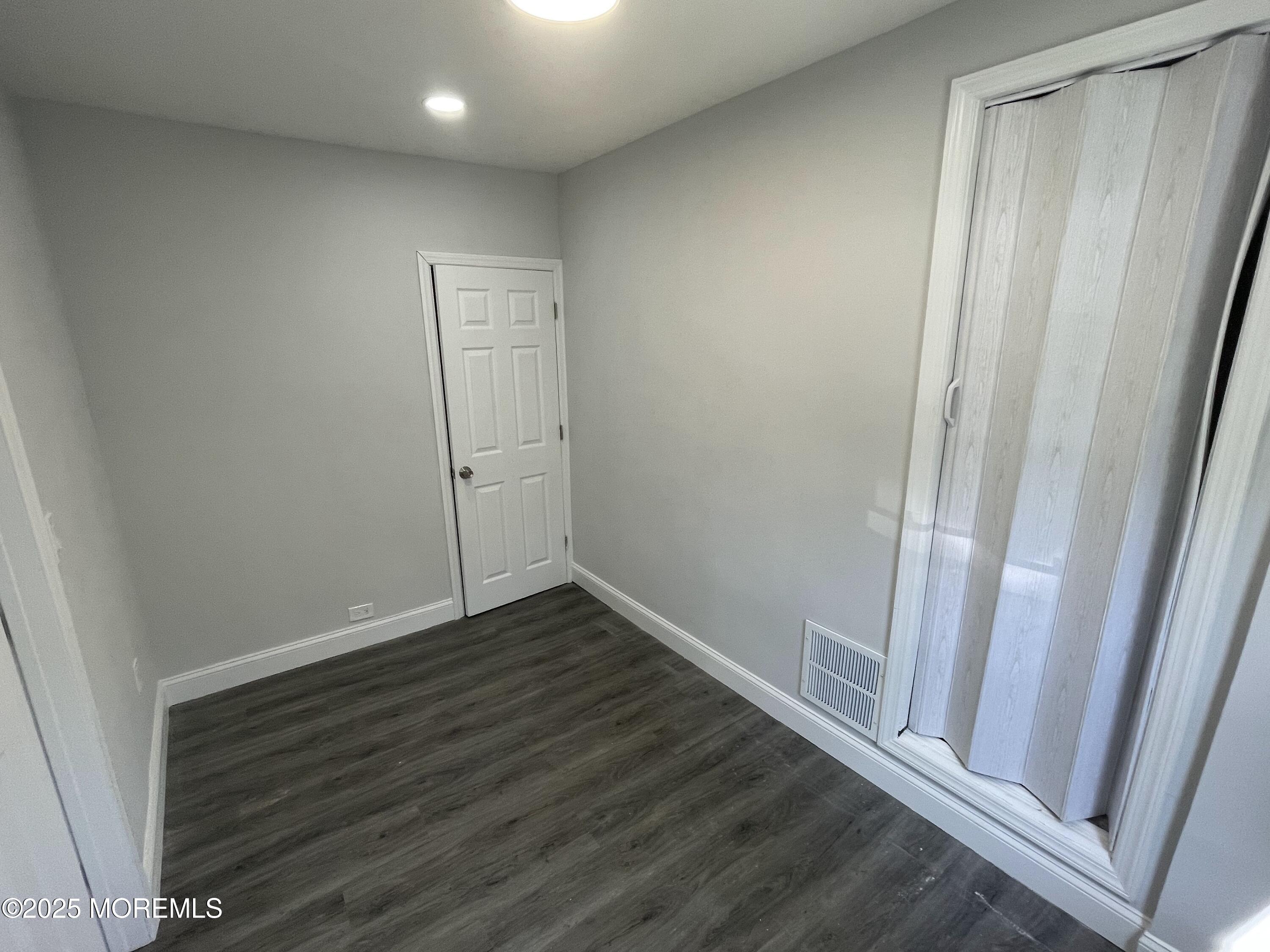 413 Ridge Avenue, Unit 3 Asbury Park, NJ 07712 - Photo 5 of 7 a view of an empty room with wooden floor and a window