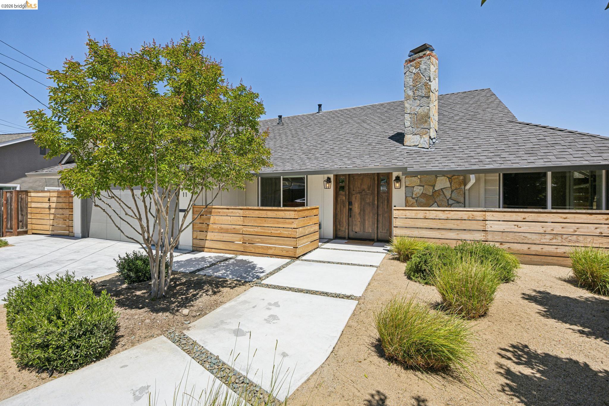 11 Belinda Court San Ramon, CA 94583 - Photo 2 of 33 Contemporary exterior showcasing a stone chimney, wood entry door, and a horizontal wood slat fence