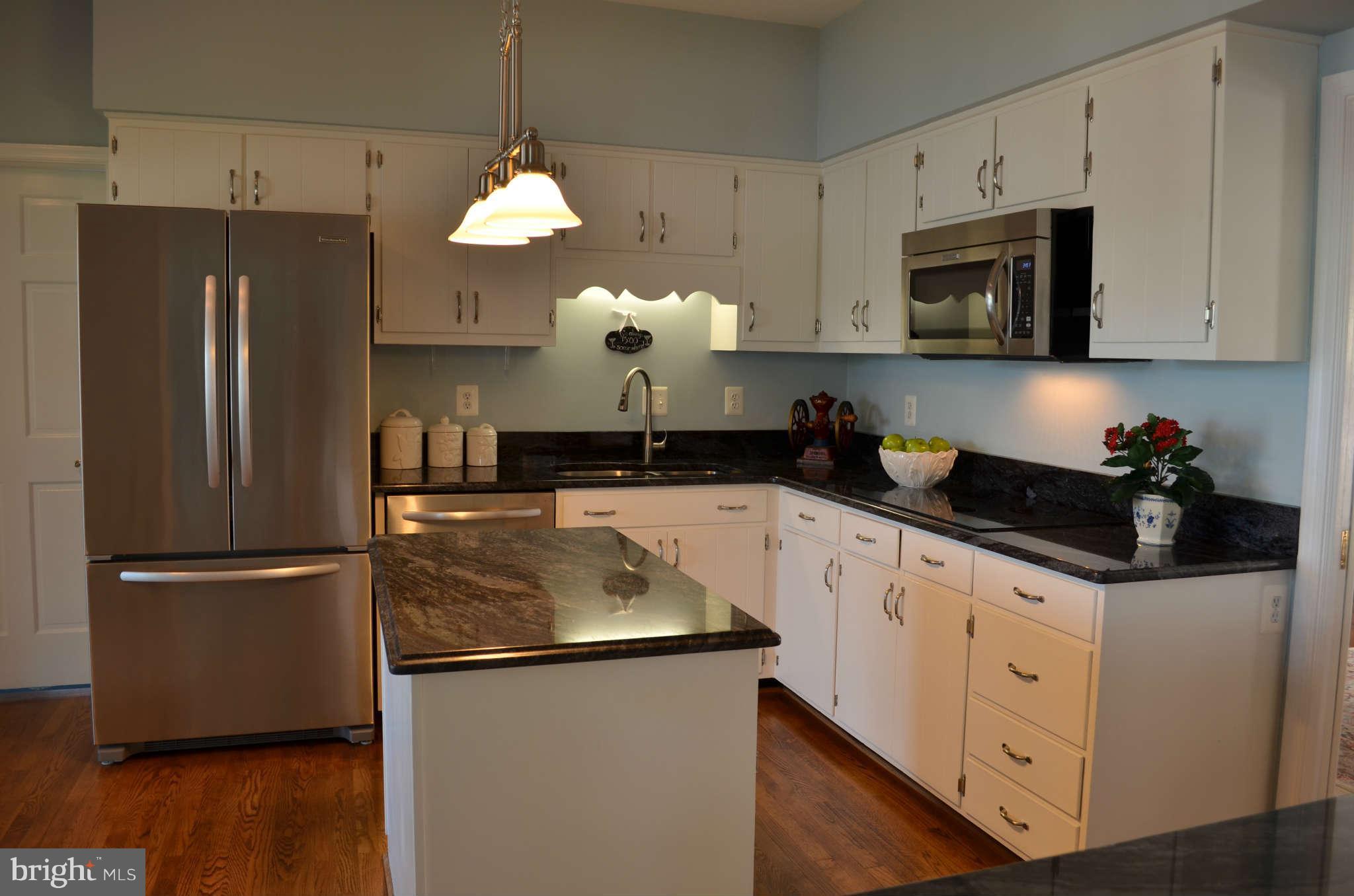 268 Providence Road Annapolis, MD 21409 - Photo 10 of 30 a kitchen with stainless steel appliances granite countertop a refrigerator a sink dishwasher a oven a dining table and chairs with wooden floor