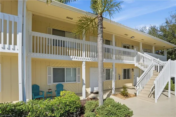 a front view of a building with a garden and plants
