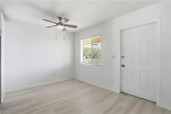 an empty room with windows and fan
