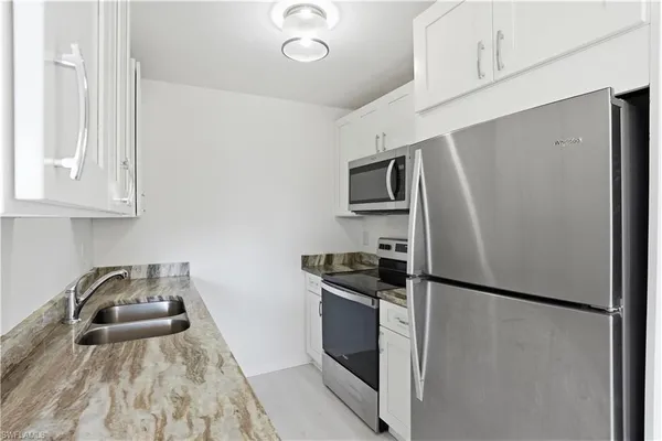 a kitchen with stainless steel appliances a refrigerator stove and microwave