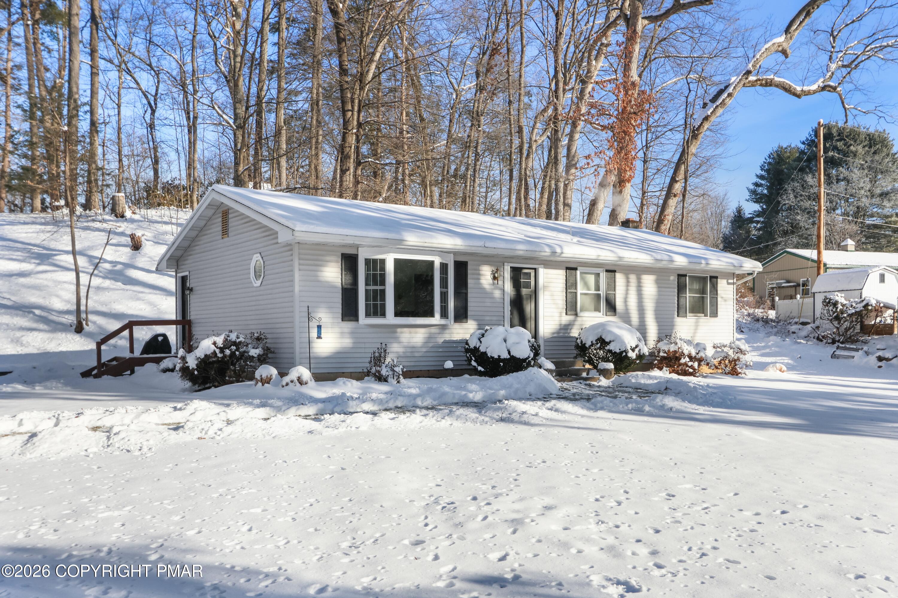 a view of a house with a yard covered in snow