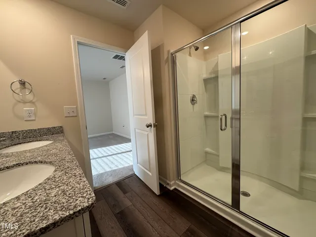 a bathroom with a granite countertop shower mirror and a sink