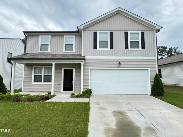 a front view of a house with a yard and garage