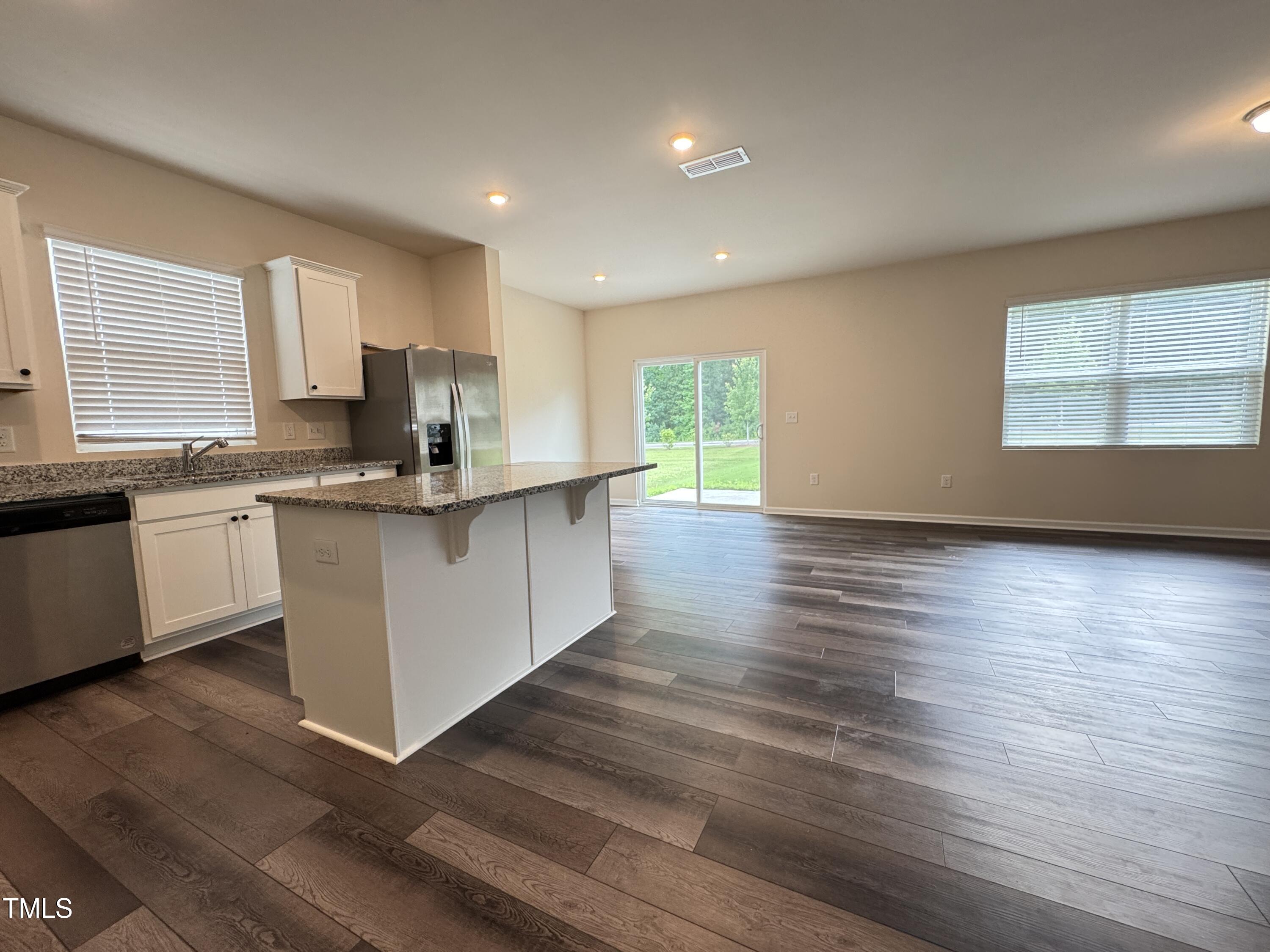 1413 Justice Union Court Raleigh, NC 27604 - Photo 6 of 29 a kitchen with stainless steel appliances granite countertop a sink cabinets and wooden floor