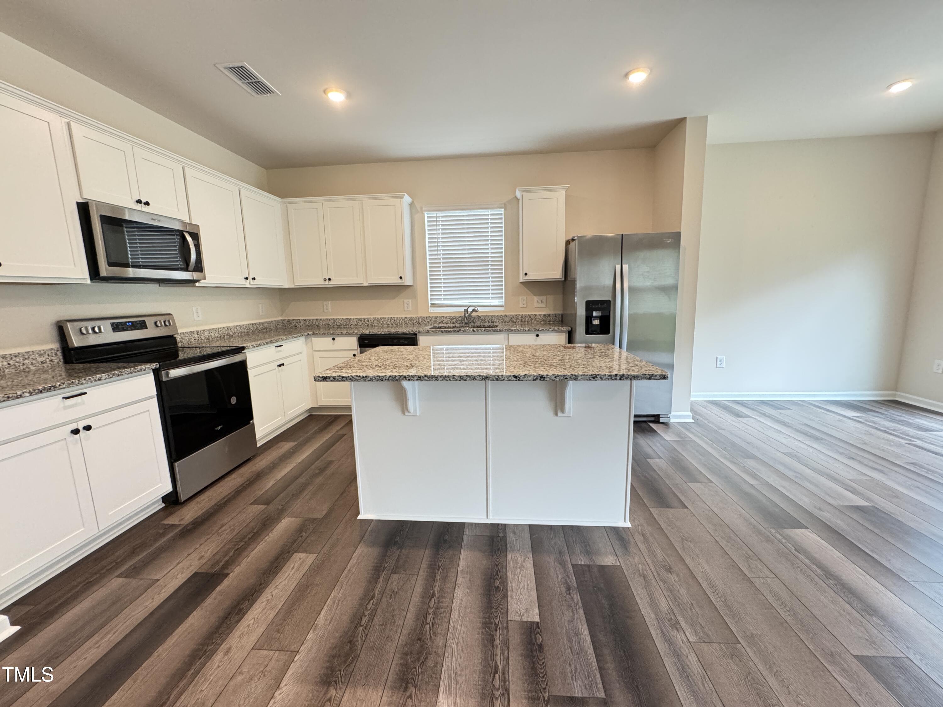 1413 Justice Union Court Raleigh, NC 27604 - Photo 9 of 29 a large kitchen with stainless steel appliances granite countertop a stove a sink dishwasher and a refrigerator with wooden floor