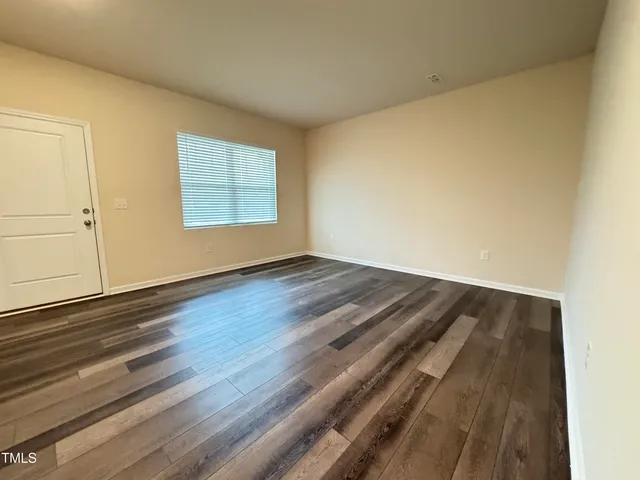 a view of a room with wooden floor and window