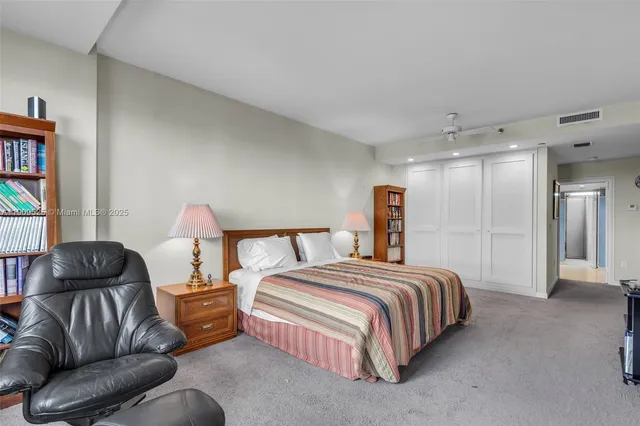 a spacious bedroom with a bed and a book shelf