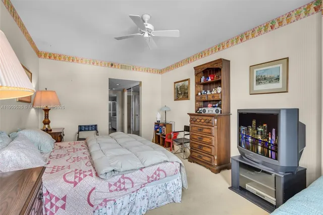 a bedroom with a large bed and a chandelier