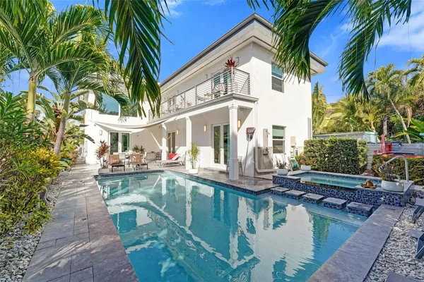 a view of house with swimming pool and sitting area