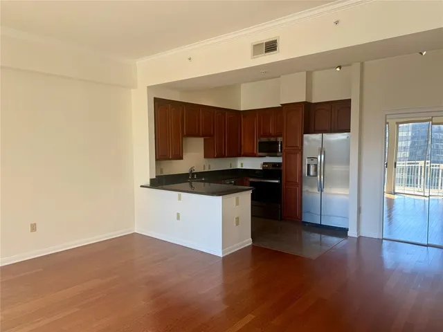 a kitchen with granite countertop a refrigerator and a stove top oven