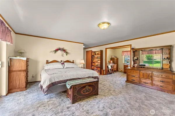 a spacious bedroom with a bed and large windows
