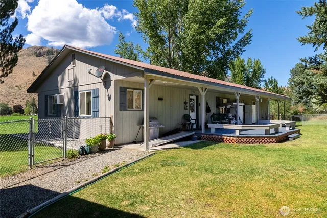 a view of house with swimming pool and a yard