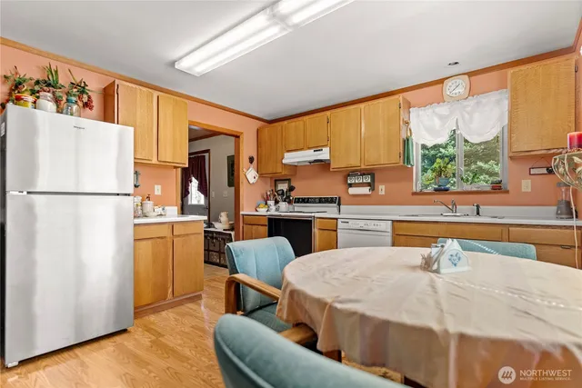 a kitchen with stainless steel appliances kitchen island granite countertop a refrigerator a stove and a sink with dishwasher