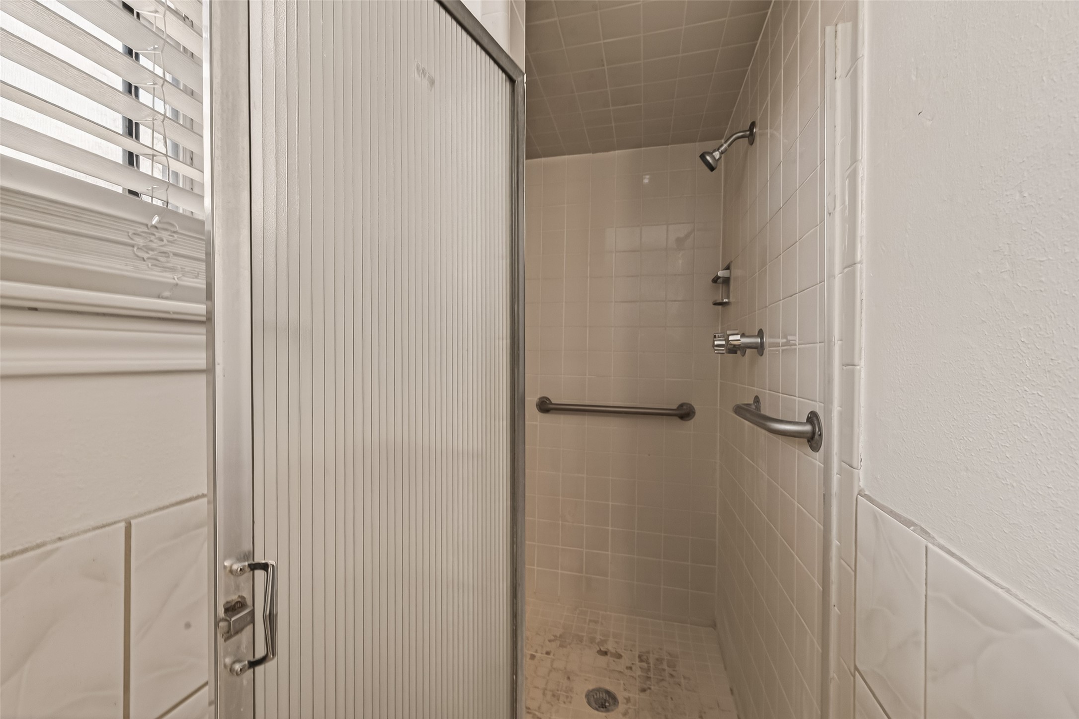 10607 Bainbridge Street Houston, TX 77016 - Photo 27 of 43 a bathroom with a glass shower door