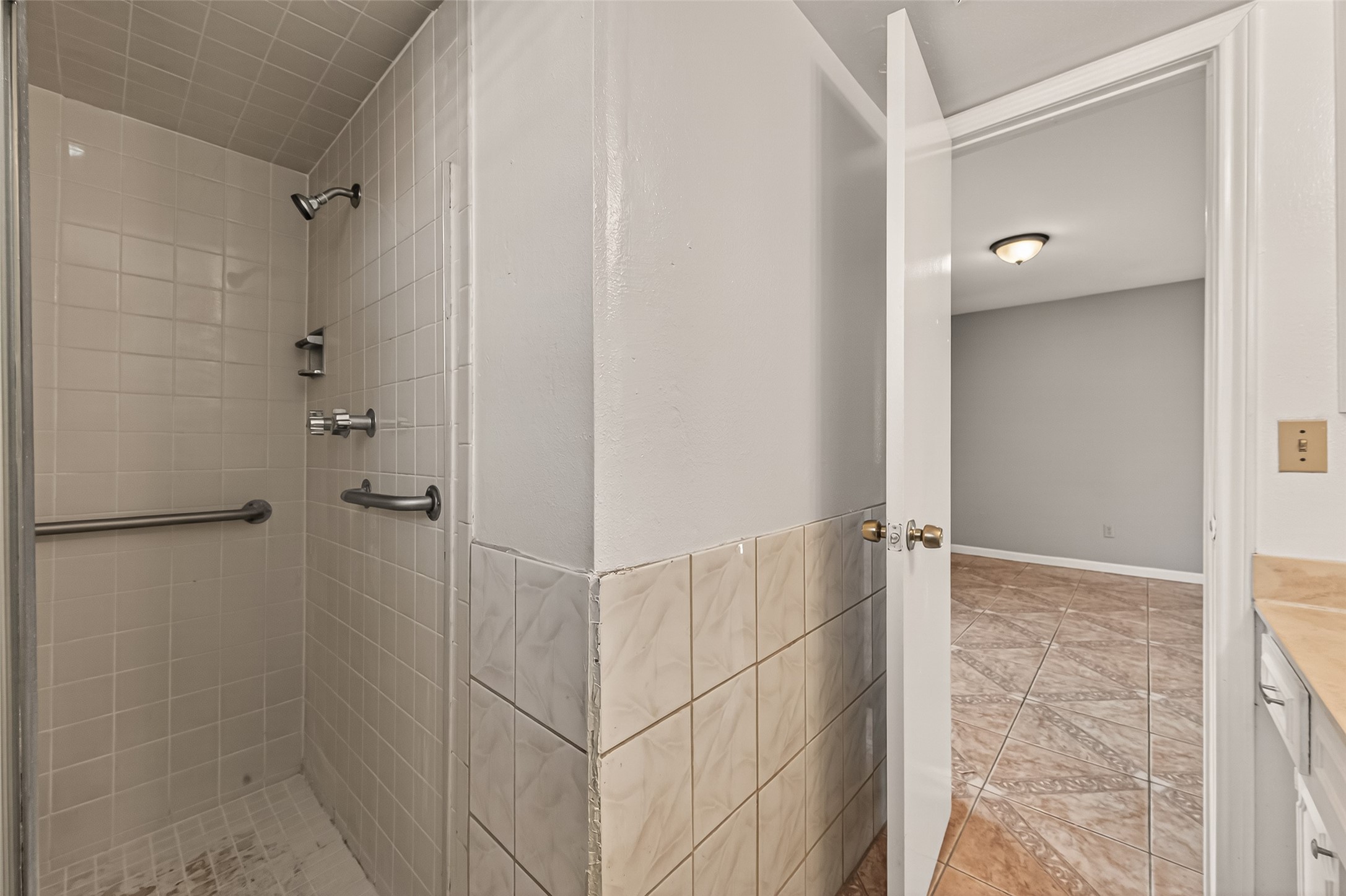 10607 Bainbridge Street Houston, TX 77016 - Photo 28 of 43 a bathroom with a glass shower door