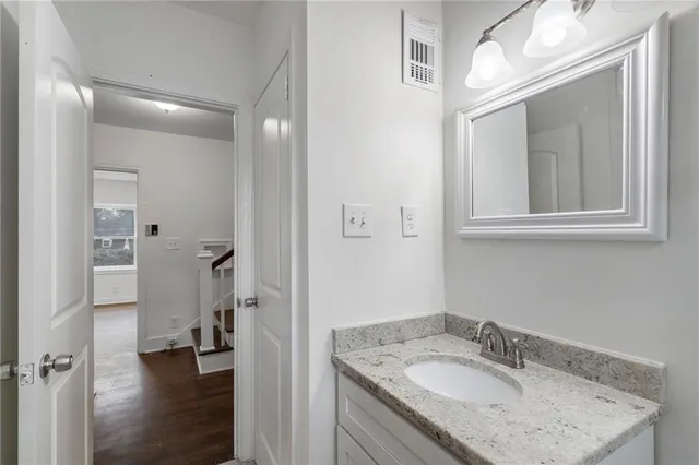 a bathroom with a granite countertop sink mirror and a toilet
