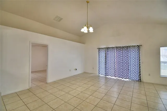 an empty room with chandelier fan