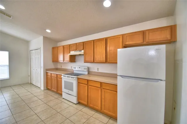 a kitchen with stainless steel appliances granite countertop a refrigerator sink and cabinets