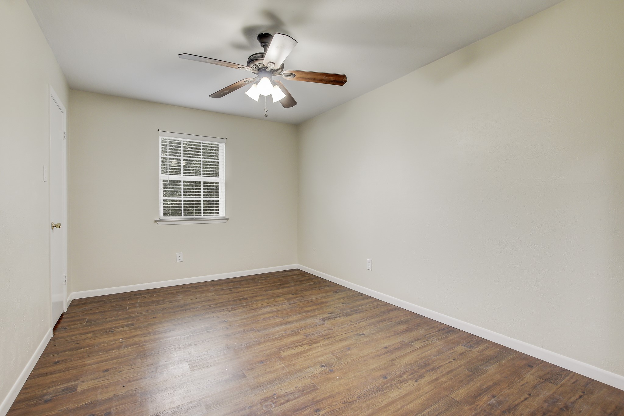 6902 Rifle Bend Austin, TX 78736 - Photo 22 of 33 an empty room with wooden floor chandelier fan and windows