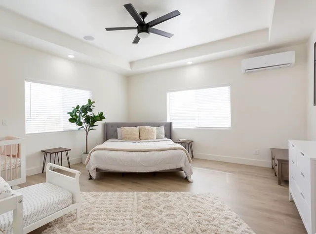 a spacious bedroom with a bed a couch and a potted plant