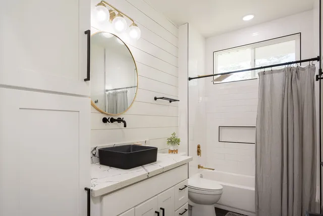 a bathroom with a sink a toilet and shower