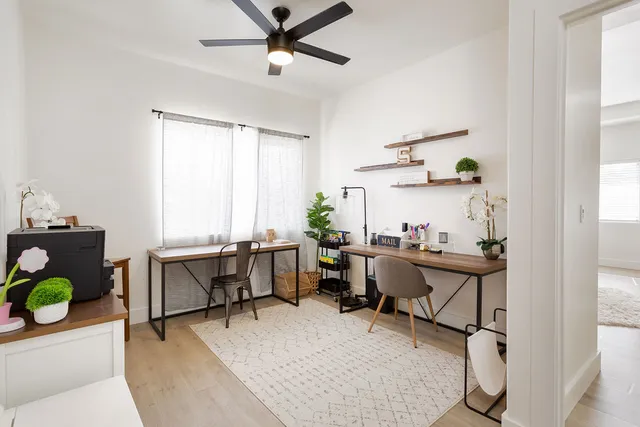 a view of a workspace with furniture and a window