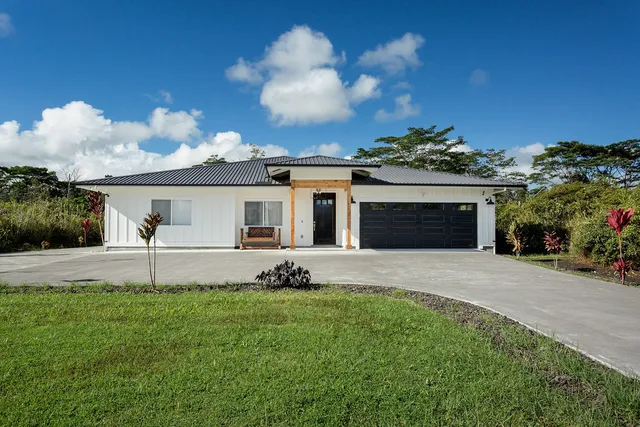 a front view of a house with a garden and yard