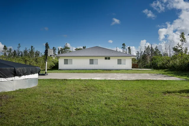 a front view of a house with a garden and yard